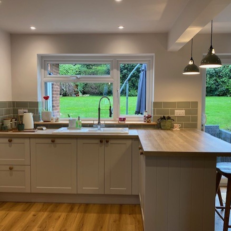 A person painted kitchen walls using a paintbrush and roller. The person applied the paint using Easy care Dulux paint onto the walls and woodwork