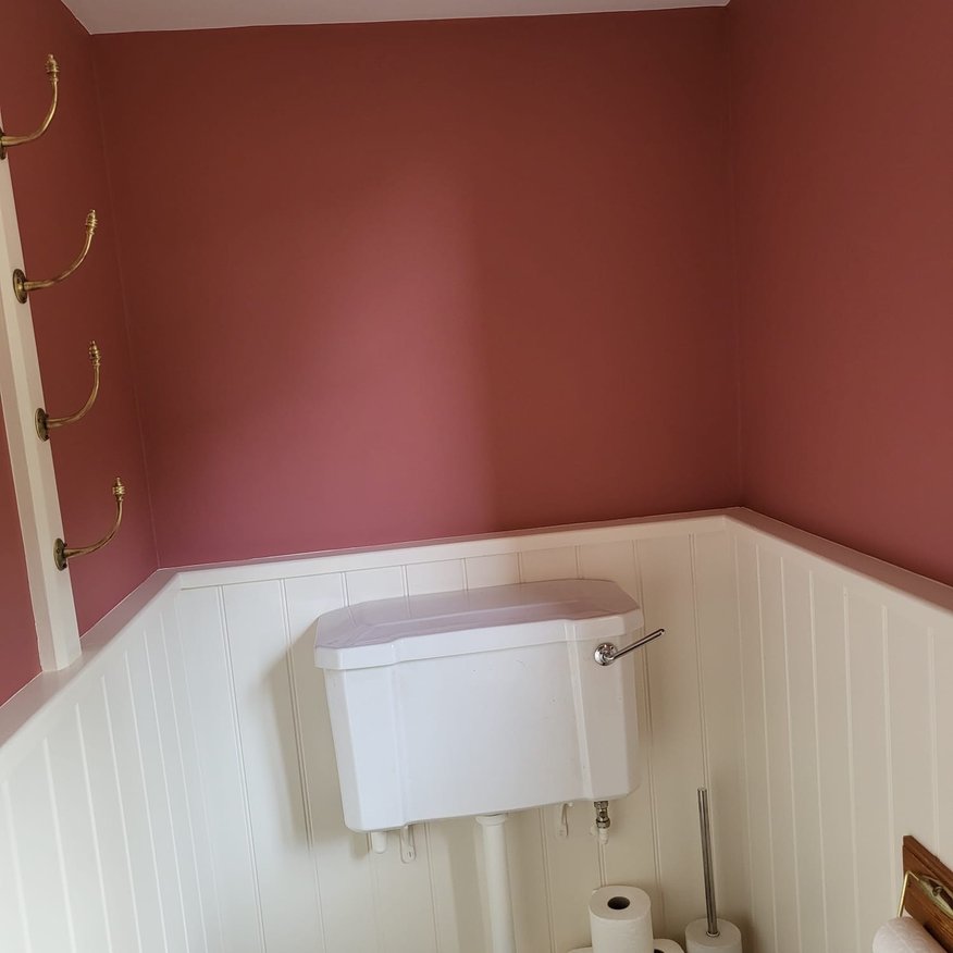 Paint brush for woodwork, trim and door using pale satinwood and roller application and dark pink. Small Cloakroom transformation Herefordshire